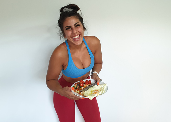 Nutritionist near Melbourne Shadi smiles to camera with a healthy meal in her hands